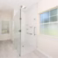 Curbless walk-in shower with grab bars and barrier-free entry designed for long-term accessibility and aging-in-place.